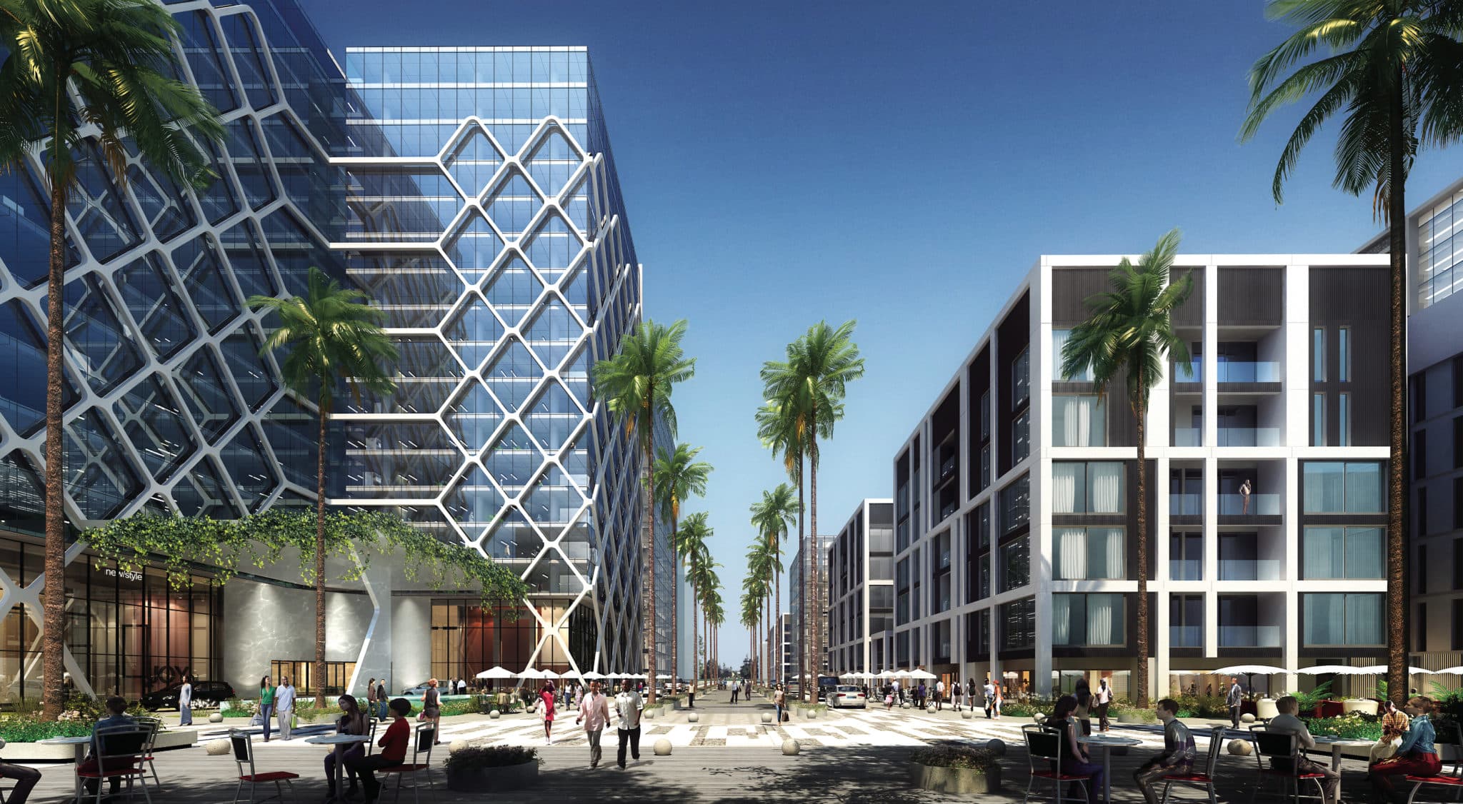 The palm-lined entrance boulevard, offices behind a diamond lattice façade on one side and apartments on the other, café tables in the foreground