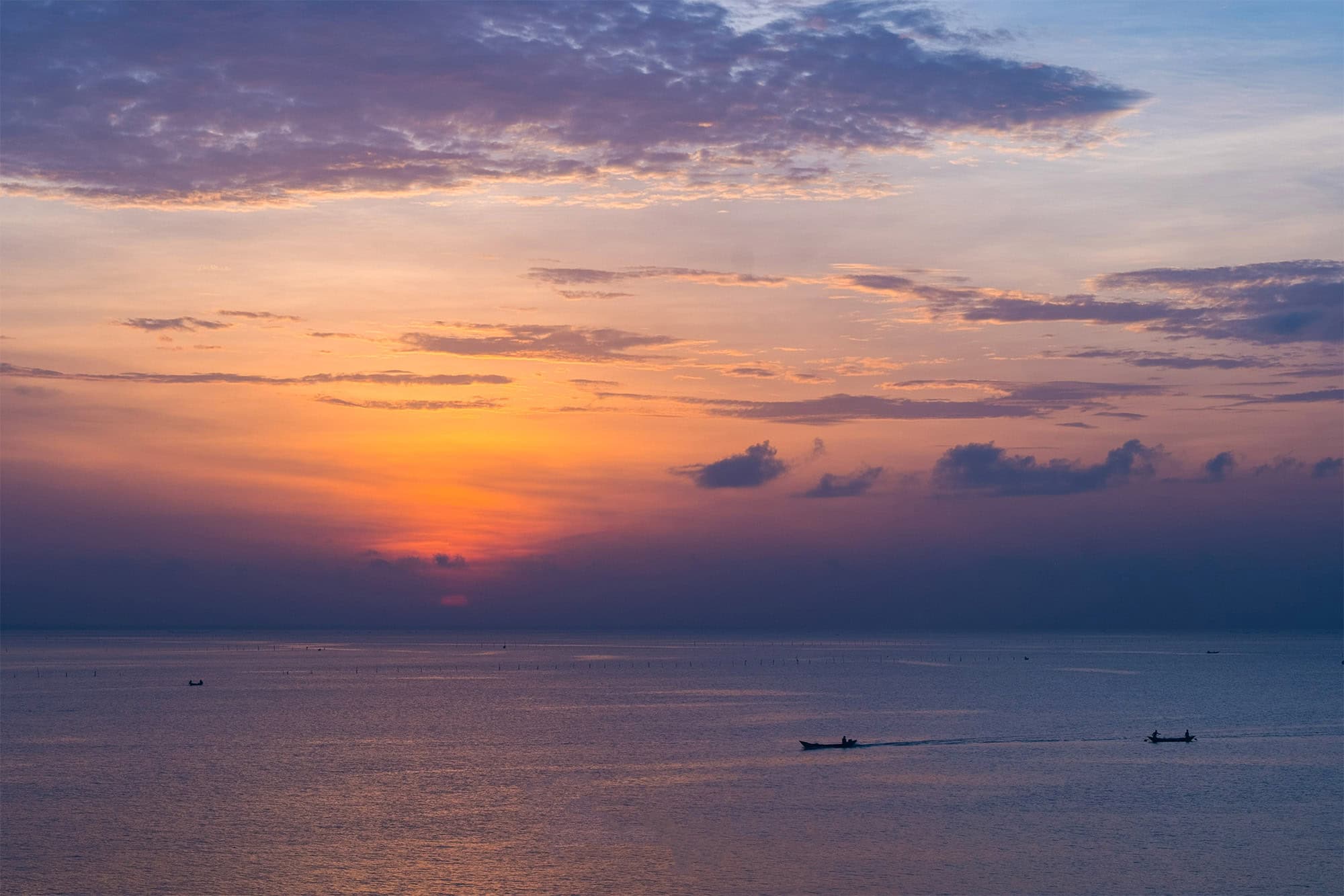 The sun going down over the lagoon, boats on the water